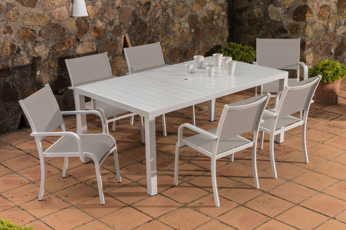 Single cheap garden table and chairs set in a tiled terrace with background of stone wall in an apartment in Mijas, Malaga, Costa del Sol, Malaga
